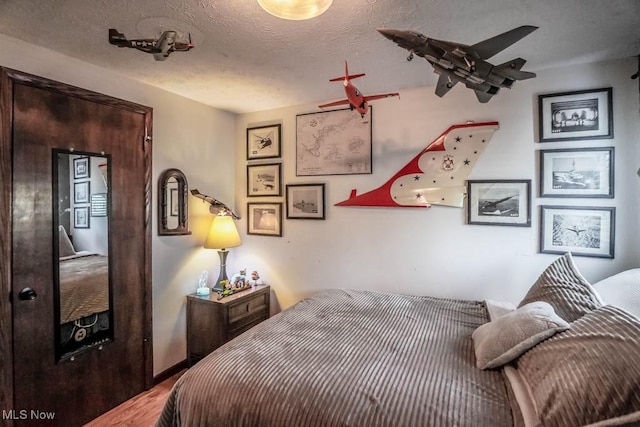 bedroom featuring wood-type flooring and a textured ceiling