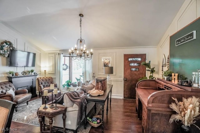 living room with dark hardwood / wood-style floors, an inviting chandelier, and lofted ceiling