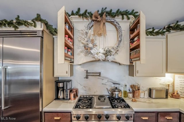 kitchen featuring stainless steel built in refrigerator, stove, and decorative backsplash