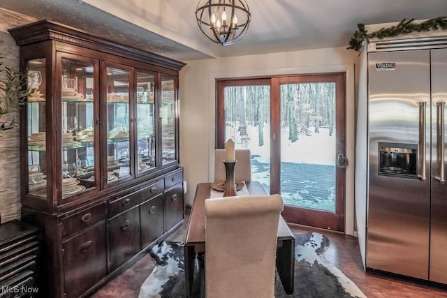 doorway to outside with dark wood-type flooring and a chandelier