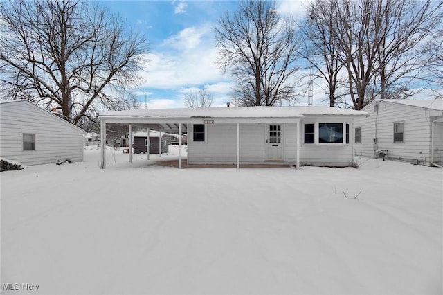 view of snow covered rear of property