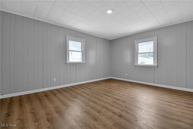 unfurnished room with wood walls and hardwood / wood-style floors