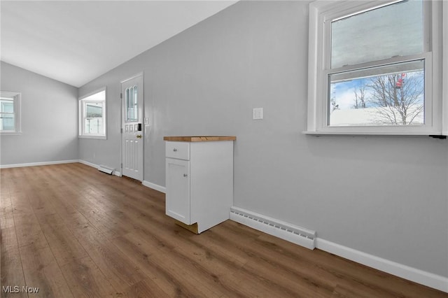 entrance foyer featuring hardwood / wood-style flooring, baseboard heating, and lofted ceiling