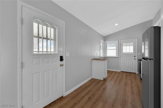 entrance foyer with hardwood / wood-style floors and vaulted ceiling