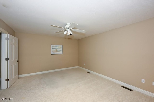 carpeted spare room featuring ceiling fan