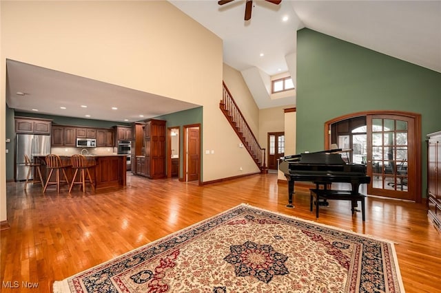 entrance foyer with light wood-type flooring, high vaulted ceiling, and ceiling fan