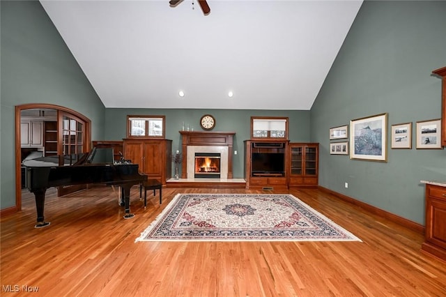 living room featuring ceiling fan, a fireplace, and light hardwood / wood-style flooring