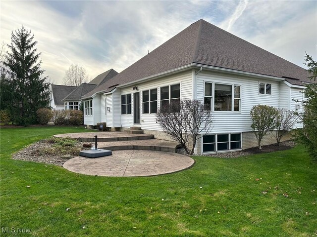 rear view of property with a yard and a patio