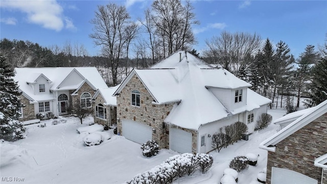 2142 Kirtland Pl, Hudson, OH 44236 - view of snow covered exterior with stone siding and a garage