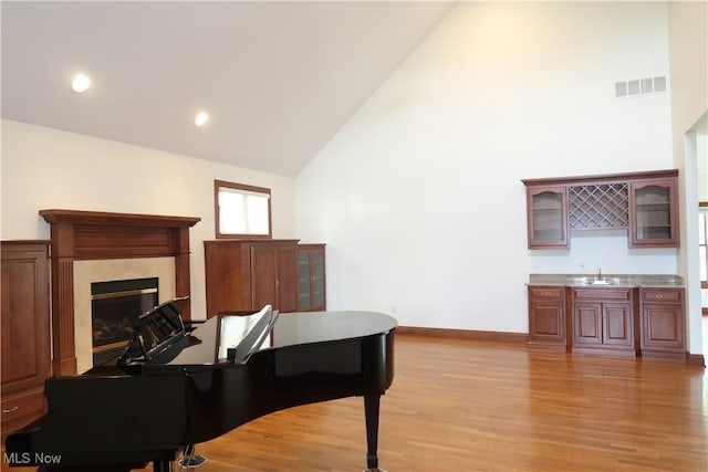 2142 Kirtland Pl, Hudson, OH 44236 - office with light wood finished floors, high vaulted ceiling, baseboards, a fireplace, and wet bar