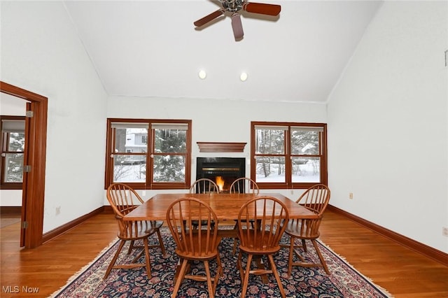 2142 Kirtland Pl, Hudson, OH 44236 - dining area featuring lofted ceiling, a warm lit fireplace, wood finished floors, plenty of natural light, and ceiling fan