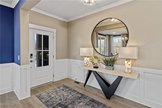 entryway featuring light hardwood / wood-style flooring and ornamental molding