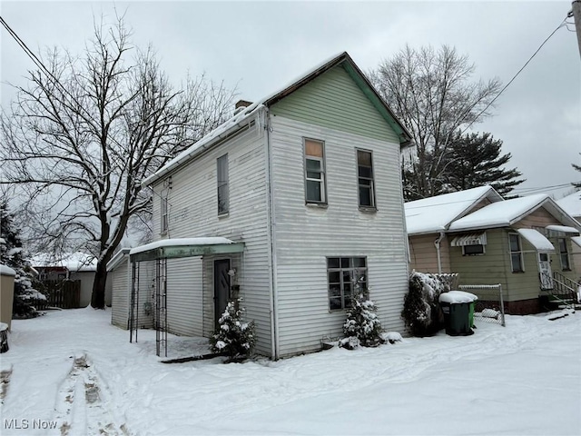 view of snow covered back of property