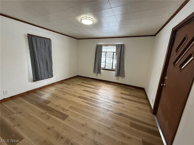 unfurnished bedroom featuring light wood finished floors, crown molding, and baseboards