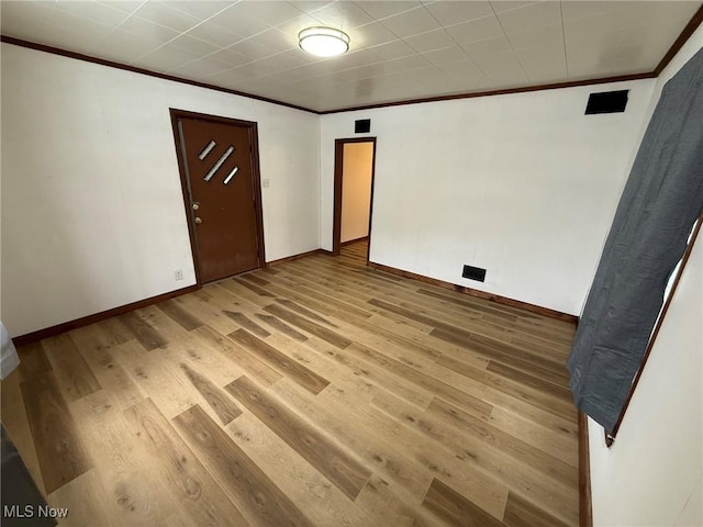 unfurnished bedroom featuring light wood-style flooring, baseboards, and ornamental molding