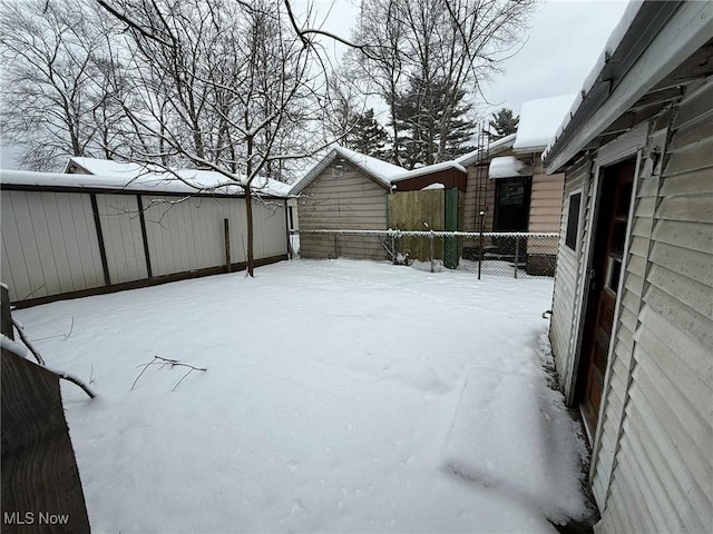 yard covered in snow featuring fence