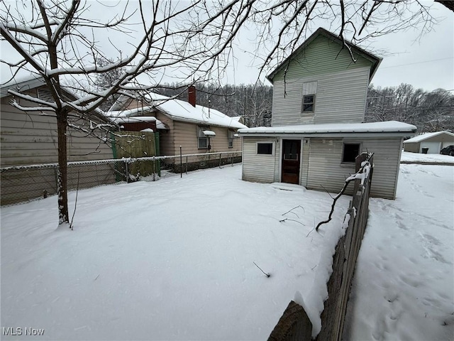 snow covered house with fence