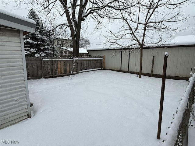 yard covered in snow featuring fence