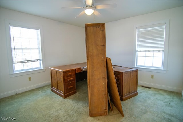 carpeted home office featuring ceiling fan and a healthy amount of sunlight