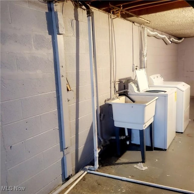 basement with washer and clothes dryer and sink