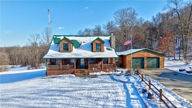 log-style house featuring a porch, an outbuilding, and a garage