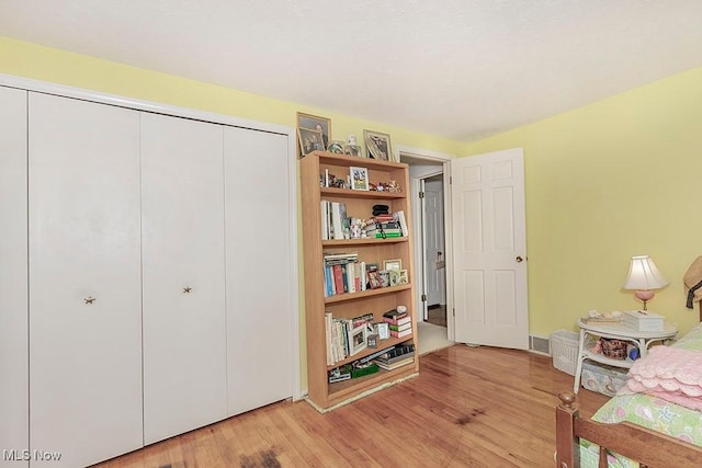 bedroom with light hardwood / wood-style floors and a closet