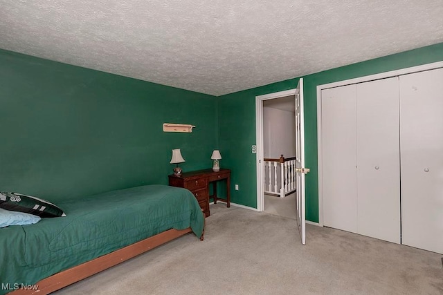 carpeted bedroom with a closet and a textured ceiling