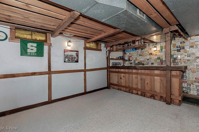 basement featuring carpet and bar