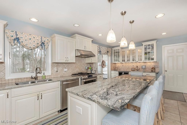 kitchen featuring white cabinetry, a center island, appliances with stainless steel finishes, and sink