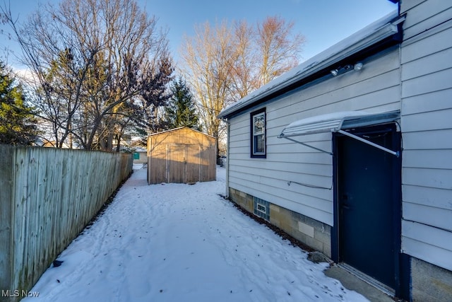 yard layered in snow with a shed