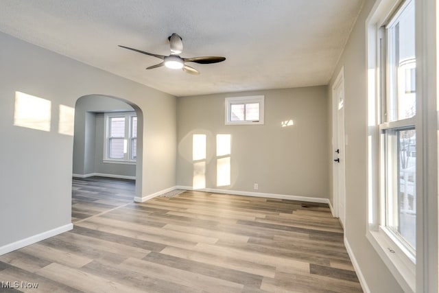 unfurnished room with ceiling fan, light hardwood / wood-style floors, and a textured ceiling