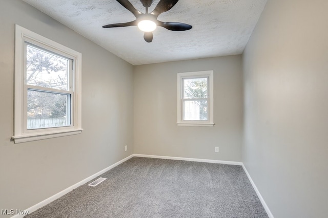 carpeted spare room with ceiling fan and a textured ceiling