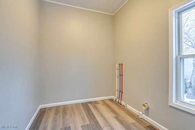 unfurnished room with a textured ceiling, light hardwood / wood-style flooring, and plenty of natural light