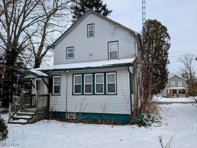 view of snow covered rear of property