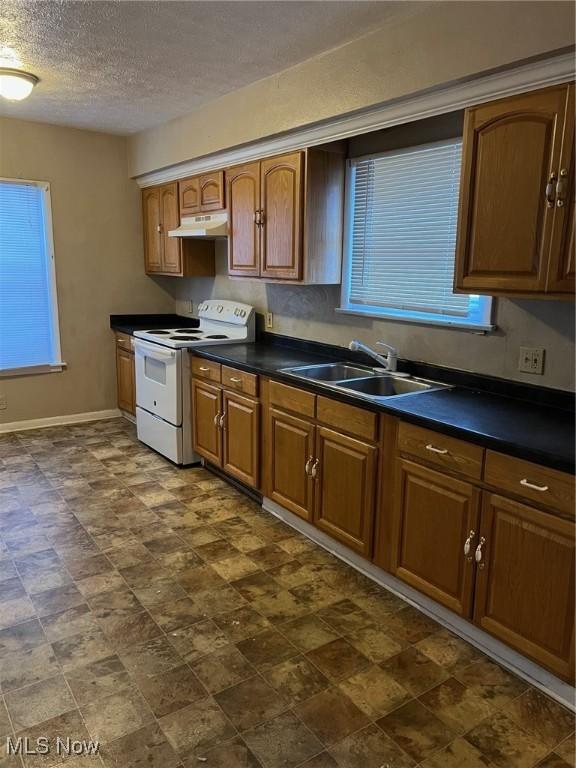 kitchen featuring plenty of natural light, sink, a textured ceiling, and white electric range