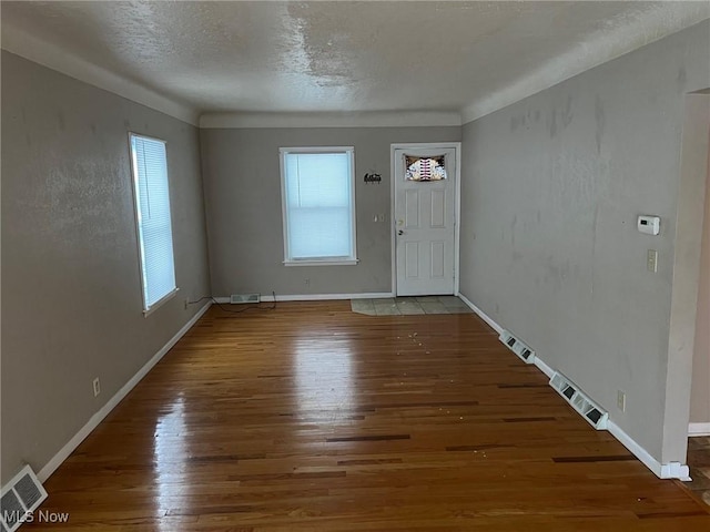 foyer entrance with dark wood-type flooring and a textured ceiling