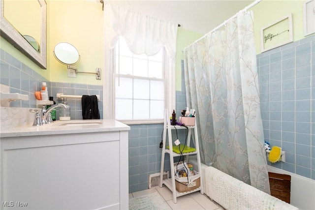 bathroom with tile patterned floors, vanity, shower / bath combination with curtain, and tile walls