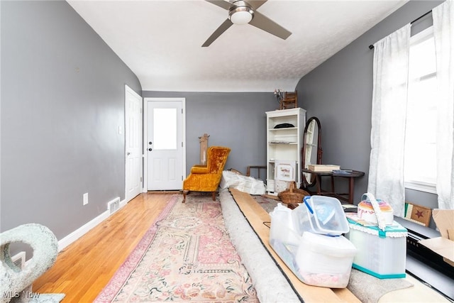 living area with ceiling fan and wood-type flooring