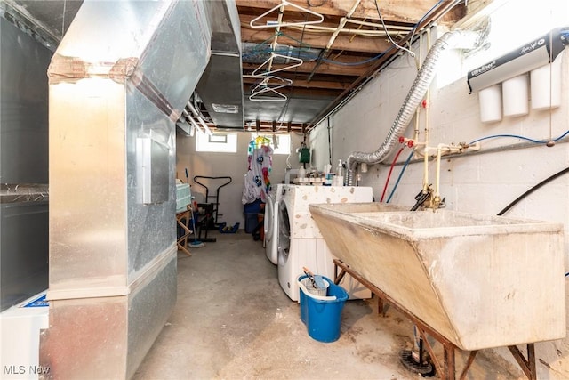 basement featuring heating unit, sink, and washing machine and clothes dryer