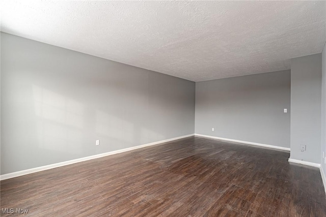 unfurnished room featuring dark hardwood / wood-style flooring and a textured ceiling