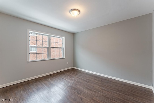 unfurnished room featuring dark wood-type flooring