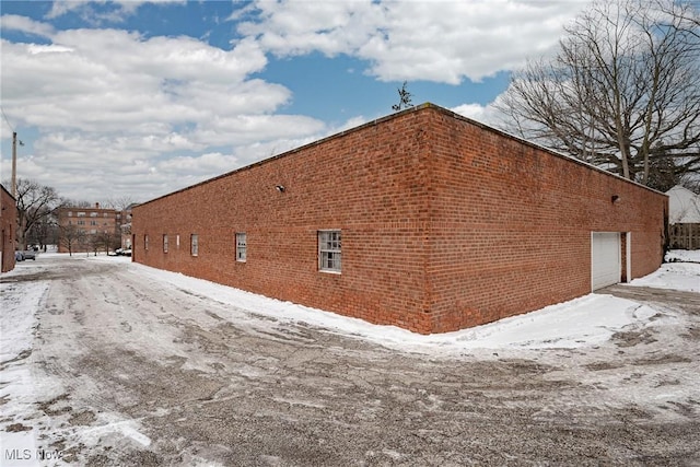 snow covered property featuring a garage