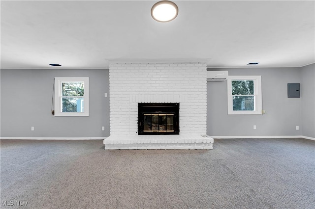 unfurnished living room featuring a wall unit AC, electric panel, carpet flooring, and a brick fireplace