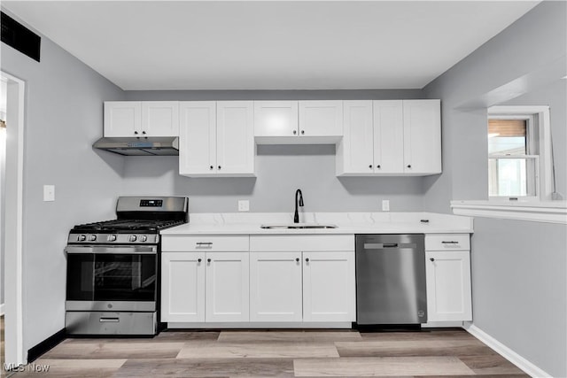 kitchen featuring sink, white cabinets, stainless steel appliances, and light hardwood / wood-style floors