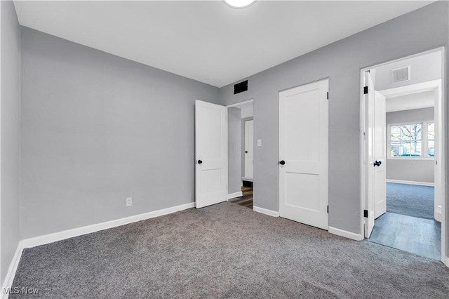 unfurnished bedroom with dark carpet