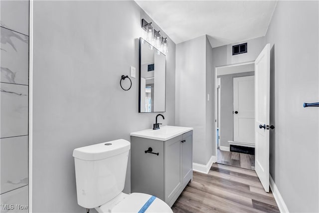 bathroom with hardwood / wood-style flooring, vanity, and toilet