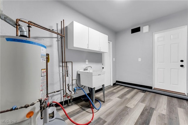 utility room with sink and gas water heater