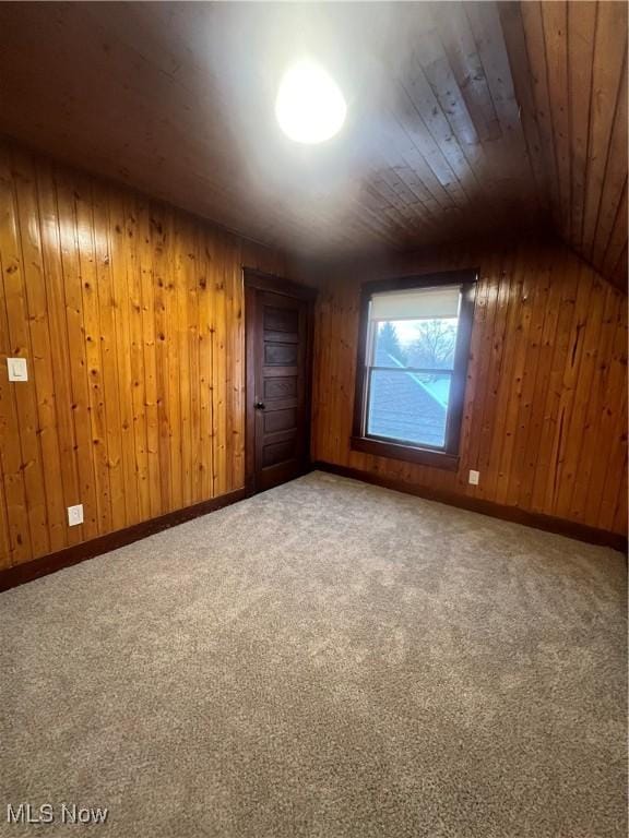 additional living space with carpet floors, wooden walls, and wood ceiling