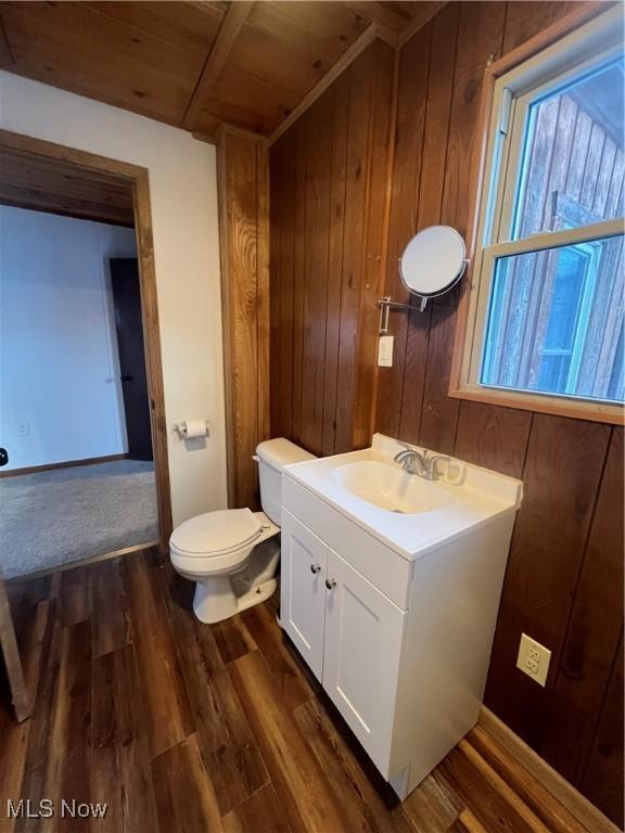 bathroom with wood walls, hardwood / wood-style floors, vanity, and wood ceiling