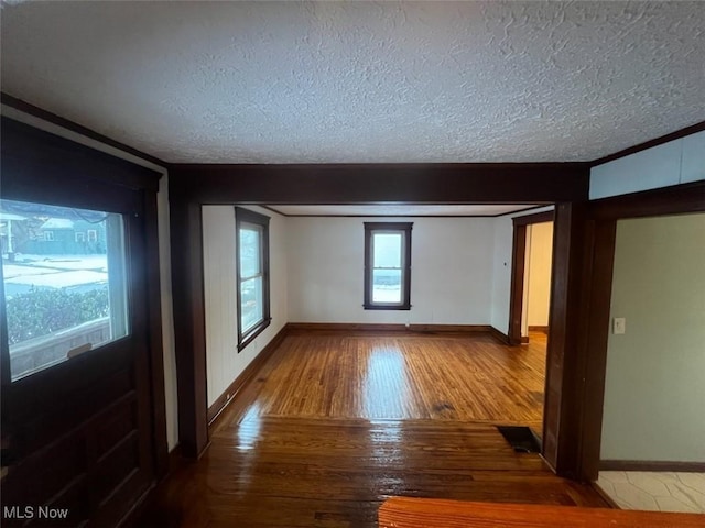 unfurnished room with wood-type flooring and a textured ceiling